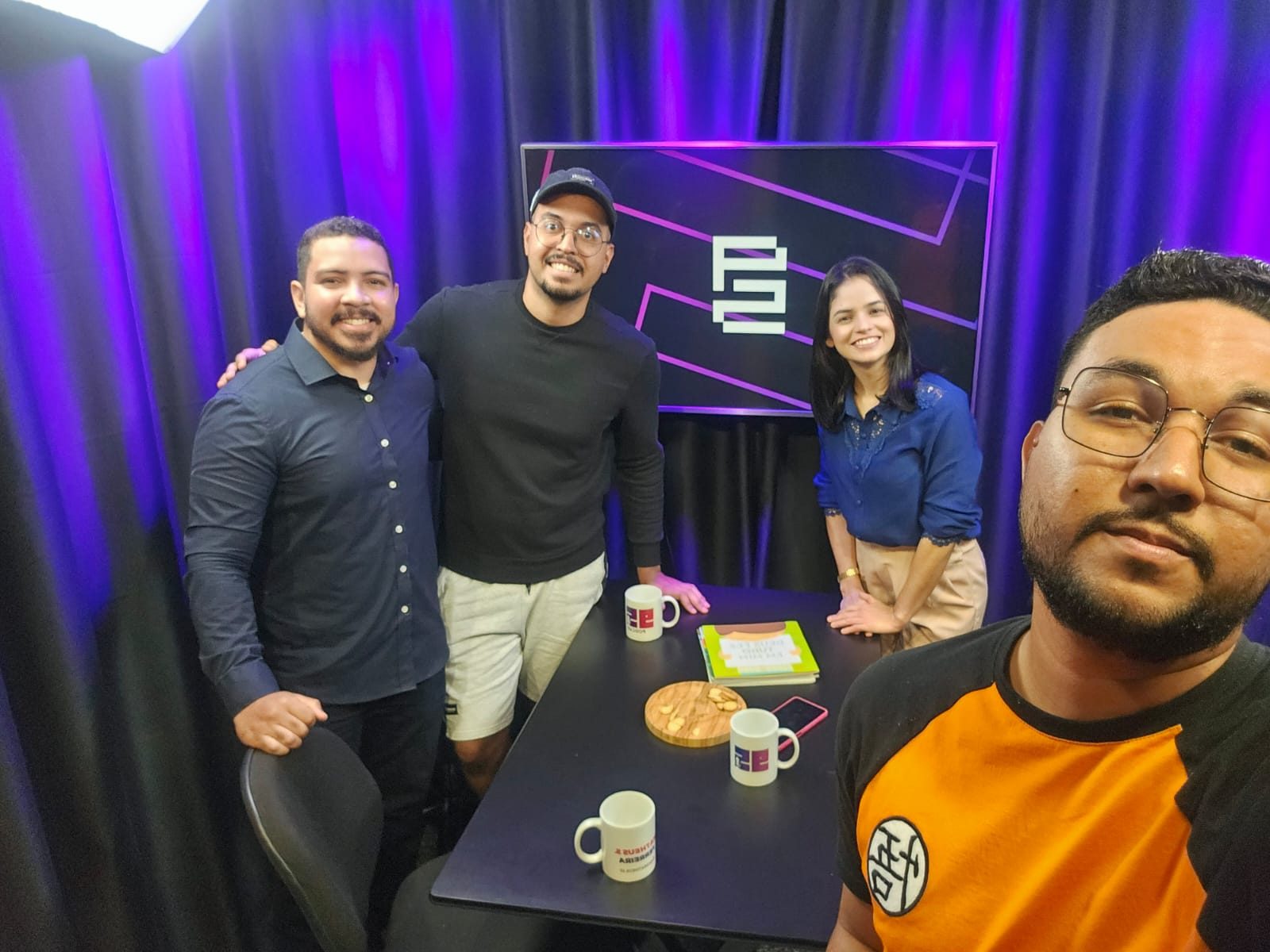 Convidados e equipe em volta da mesa do 95, com o símbolo no telão