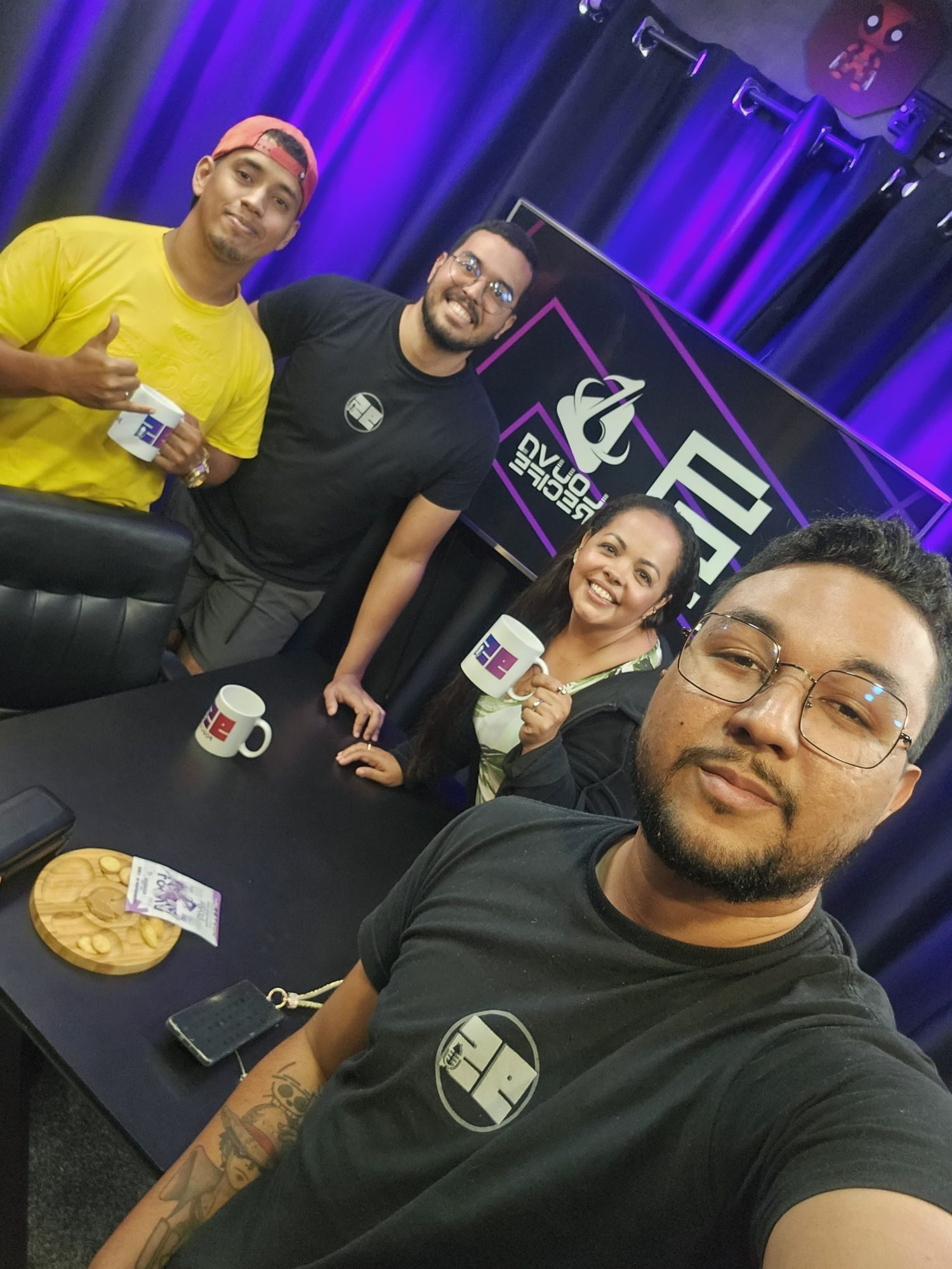 Equipe e convidados com canecas do 95 no estúdio, telão com Louva Recife